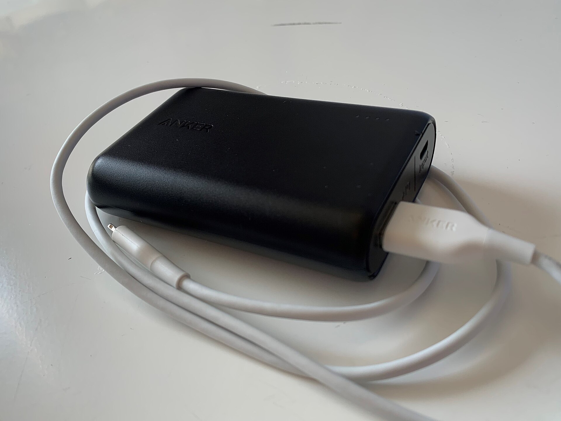 An Anker PowerCore 10000mAh power bank with a USB cable attached